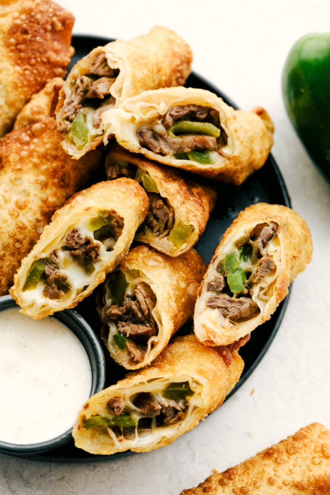 Tender meat, sautรฉed peppers and onions is smothered with cheese and wrapped in egg roll wrappers and fried to perfection in these Philly Cheesesteak Egg Rolls. This is going to be your go to appetizer or snack when you want to impress without a lot of stress. Crispy on the outside, ooey gooey on the inside Philly Cheesesteak Egg Rolls