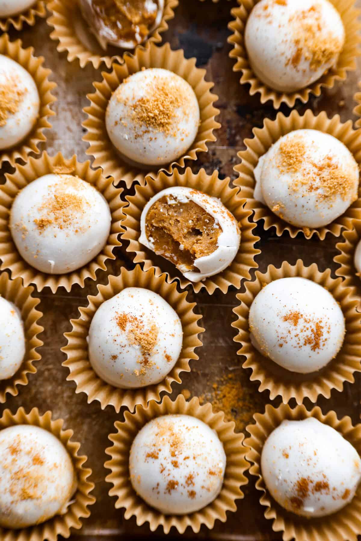 Pumpkin cream cheese truffles combine smooth cream cheese, pumpkin puree, crunchy graham cracker, and gingersnap crumbs, all dunked in sweet white chocolate. The best fall dessert. Overhead shot of the pumpkin cream cheese truffles.