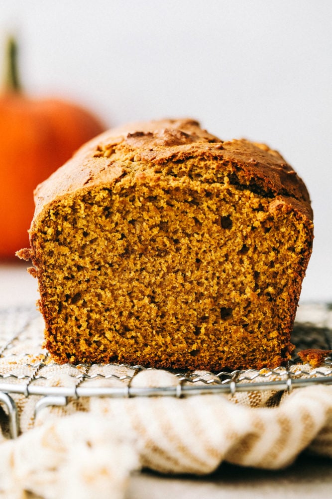 This Absolutely Perfect Pumpkin Bread is moist, spiced and will fill your home with the most amazing aroma. Your friends and family will devour this flavorful bread that screams it's time for fall. This is such an easy quick bread, you'll make it all the time. Perfectly spiced moist and tender pumpkin bread on a wire rack.