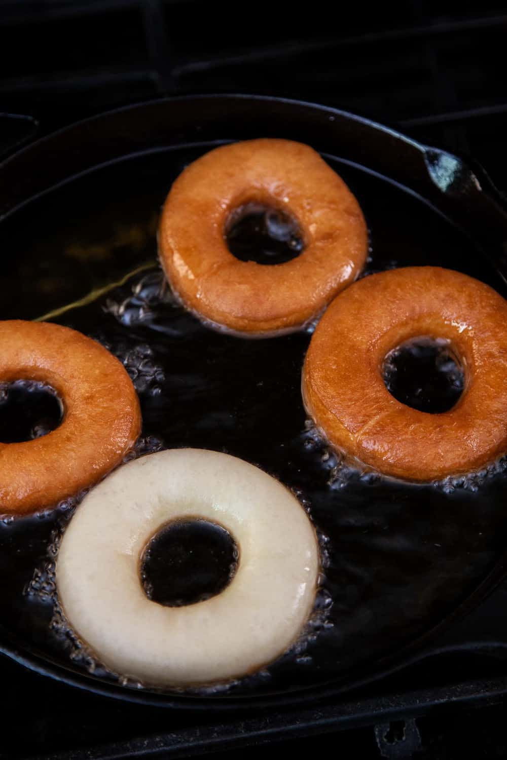 Homemade Donuts are easier to make than you might think! And yes, I’m talking about soft and fluffy fried yeasted donuts, dressed in your choice of vanilla or chocolate glaze. Frying donuts in a cast iron pan