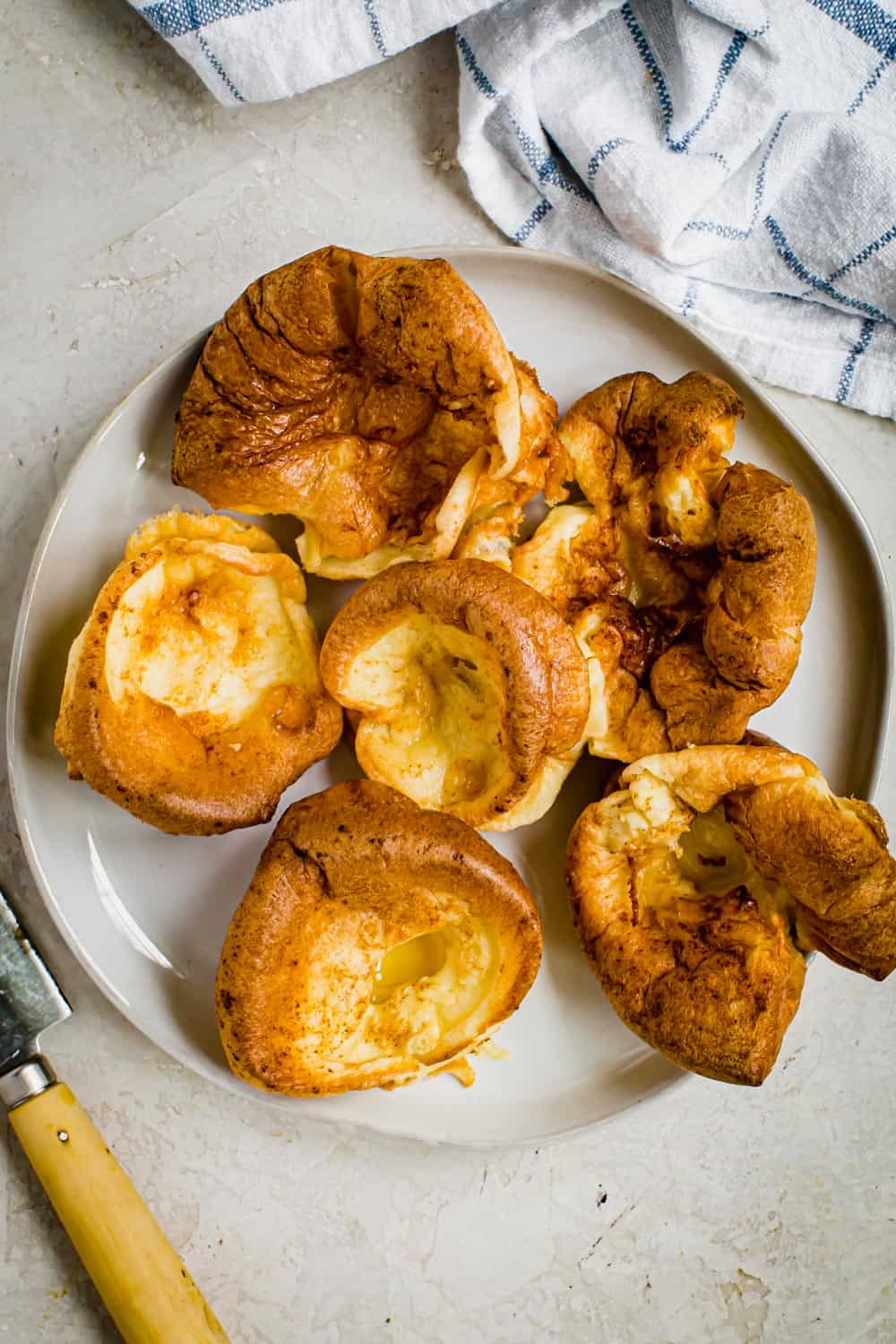 Light and fluffy with an egg-like taste, Yorkshire Pudding is a delicious side dish perfect for serving with your Sunday roast. This easy recipe will show you how to prepare the dish traditionally with beef drippings or using standard fats like butter and oil. Individual Yorkshire pudding on a white plate.