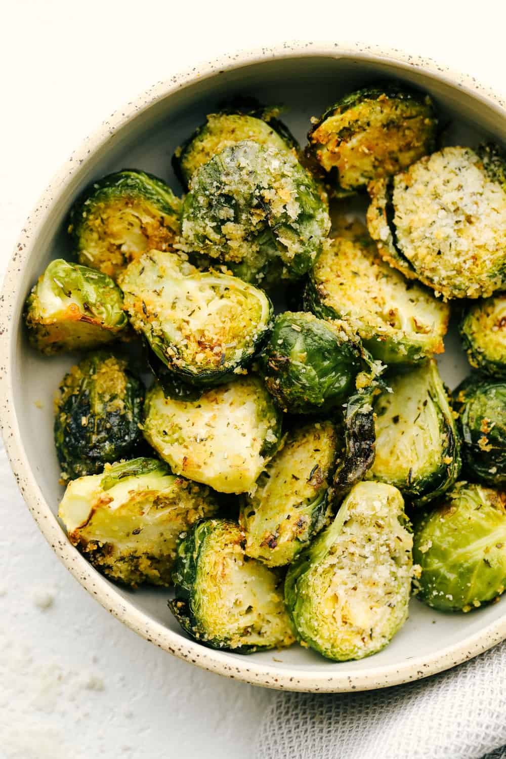 Crispy Parmesan Air Fryer Brussels Sprouts are super easy, packed with flavor and have tasty golden crunch. This is going to be one of the best ways to get your kids to say "More Please!" when it comes to their veggies. These are just that good! Parmesan crusted air fryer brussel sprouts.