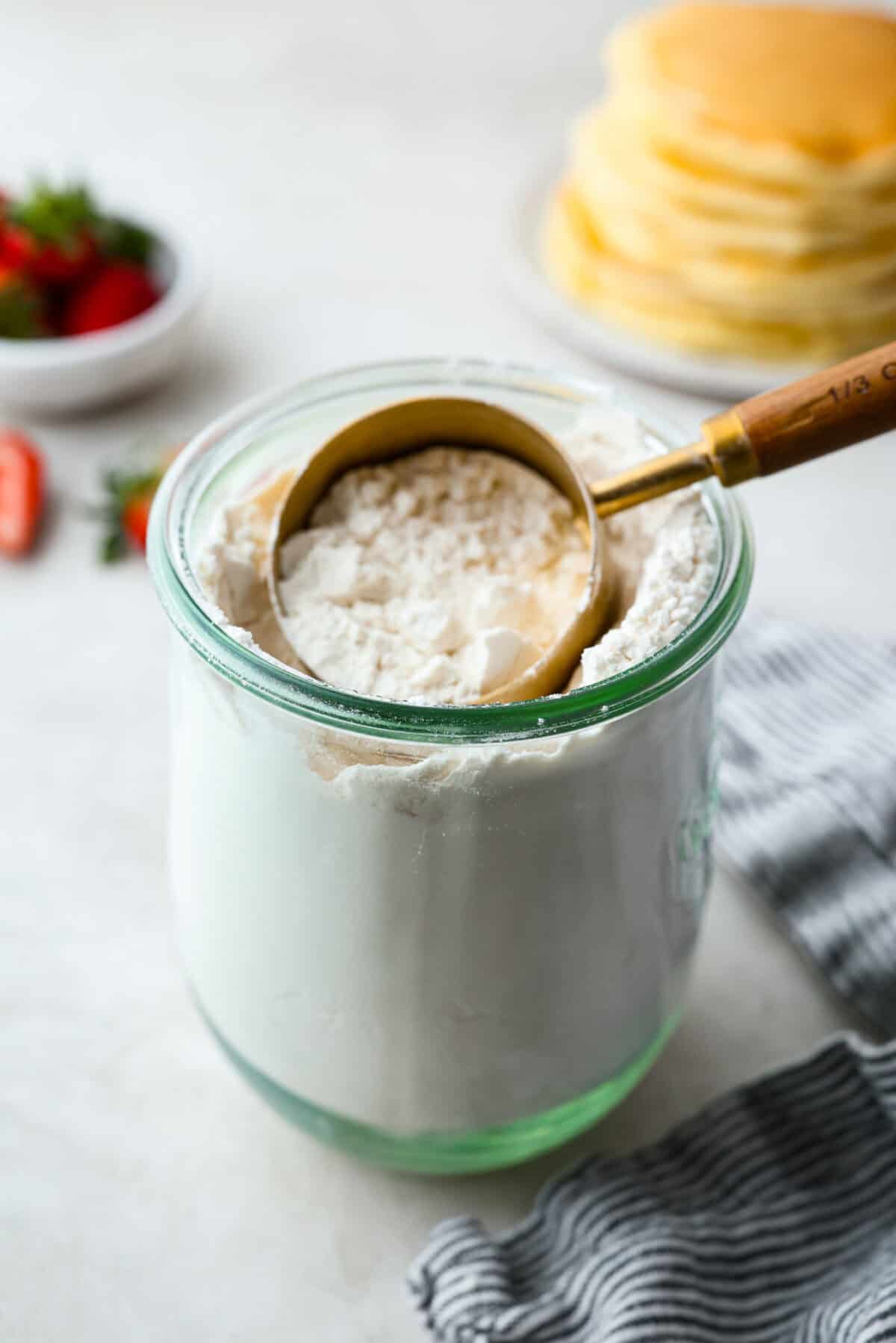 Homemade pancake mix in a cup with a measuring cup. 