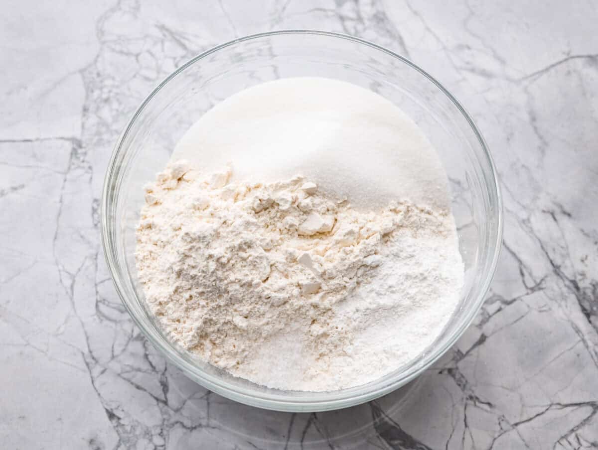My Homemade Pancake Mix uses 4 pantry staple ingredients and only takes 5 minutes to make! Ditch the box and make this simple mix for fluffy, delicate pancakes anytime! Flour, sugar, baking powder, and salt in a mixing bowl.