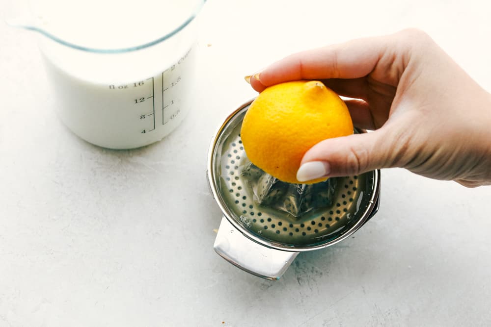 This Buttermilk is a simple recipe that will be a staple in your recipe book. Learn how to make buttermilk in two easy steps!ย Squeezing lemon juice for homemade buttermilk.