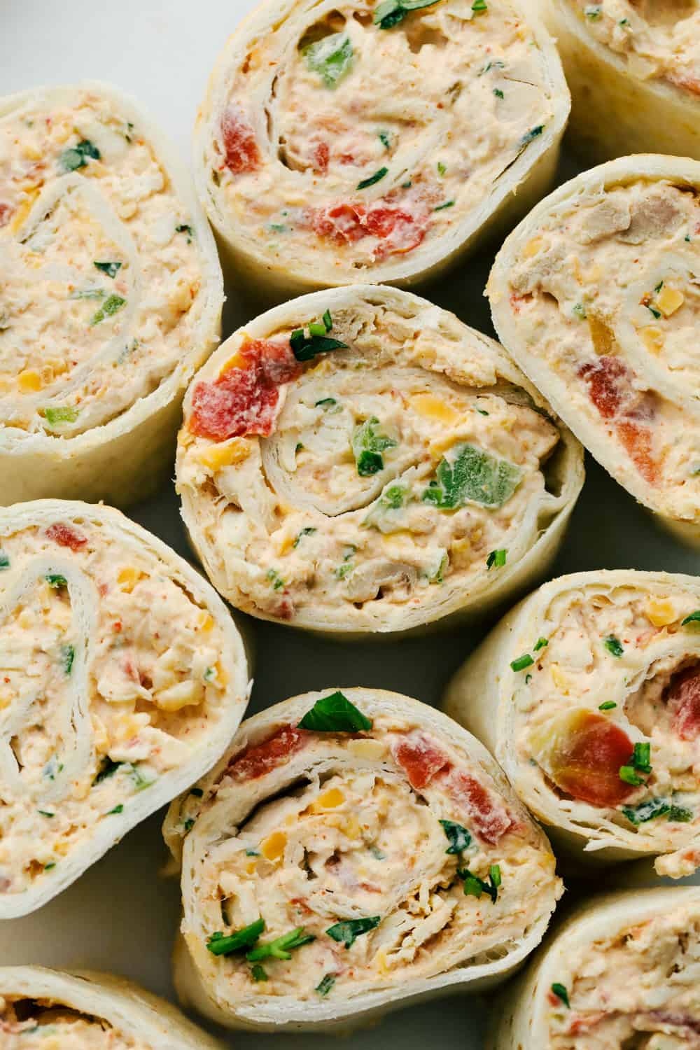 Mexican Pinwheels are a slightly spiced creamy chicken blend rolled up in easy to eat bite sized pinwheels. Soft pillowy tortillas wrapped around colorful, amazing flavored filling are going to be a hit at your next gathering! Up close photo of the Mexican pinwheels.