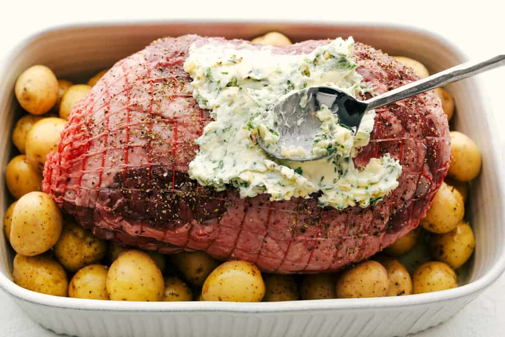 Savory Garlic Herb Crusted Roast Lamb is tender and succulent, perfect for any special occasion. The meat is tender and juicy and the crust gives it such a beautiful flavor. Perfection on a platter! Puting the Garlic Herb Crust on the lamb for roasting.