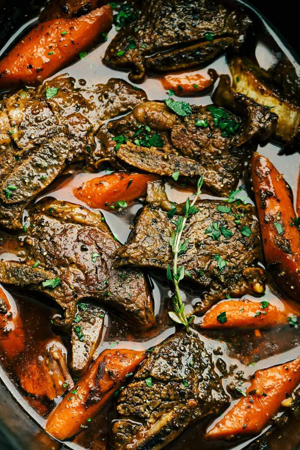Fall-off-the-bone slow cooker short ribs are a perfectly hearty and savory dinner! This is the best way to cook succulent beef and fork-tender carrots that are emerged in a delicious sauce that is full of flavor. Tender, juicy flavorful Slow Cooker Short Ribs with carrots