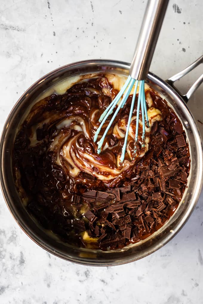 Chocolate Pie has an easy, homemade chocolate pudding that is the perfect pie filling! Smooth and creamy chocolate layered with sweet, vanilla whipped cream is the perfect dessert.ย Melting the chocolate pudding in a pot with a whisk.