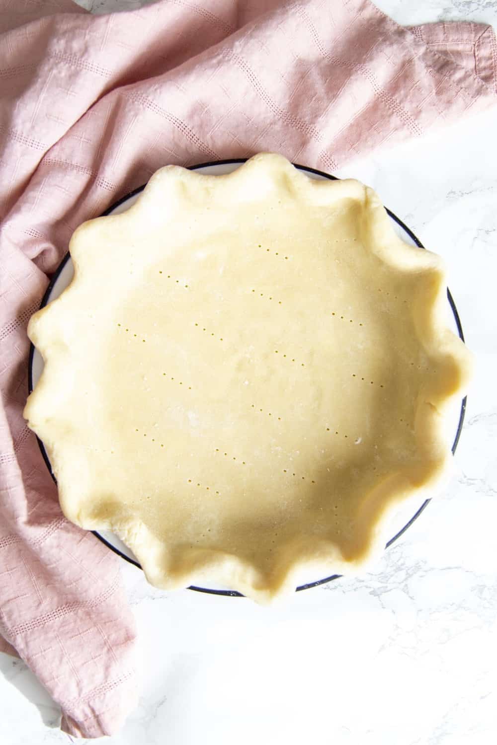 A flakey crust is filled with a decadent, dreamy, creamy, chocolate filling and topped with pillows of cream for this irresistible French Silk Pie. The filling is so smooth and rich, and then encased in a buttery crust. Pie Crust in a pie plate ready for baking.