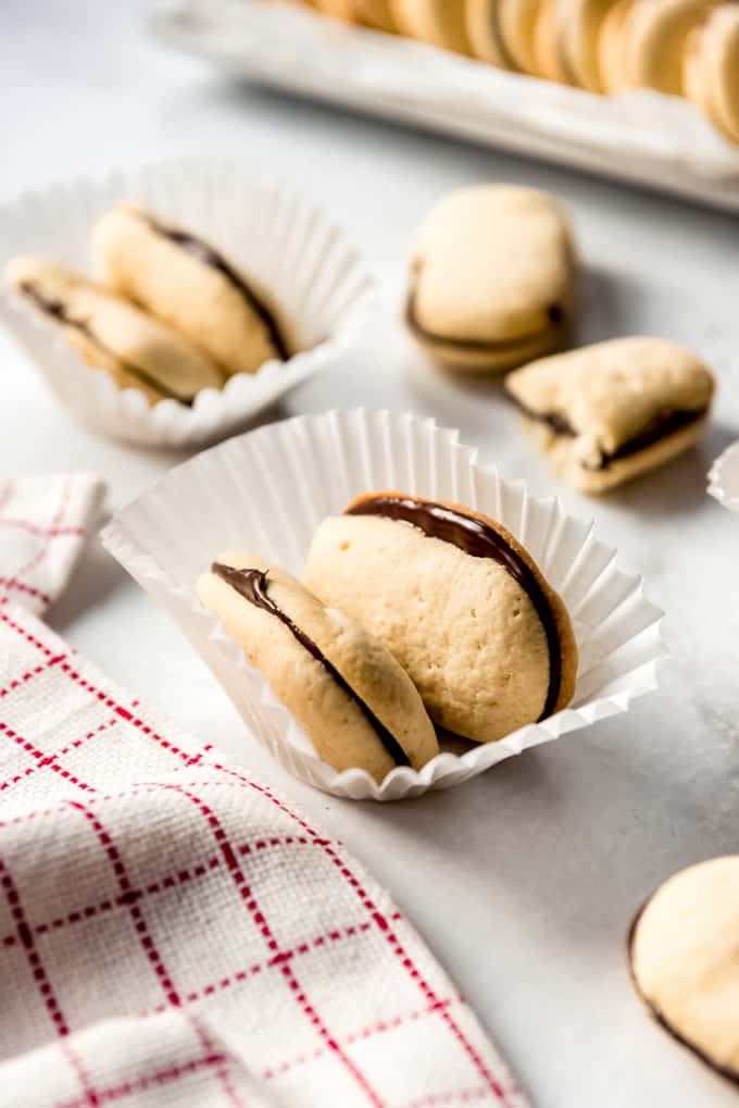 Homemade Milano Cookies have tender cookies with a nice crunch sandwiched around a layer of rich dark chocolate in the center! They taste even better than the store bought version! Milano cookies in a paper dish.