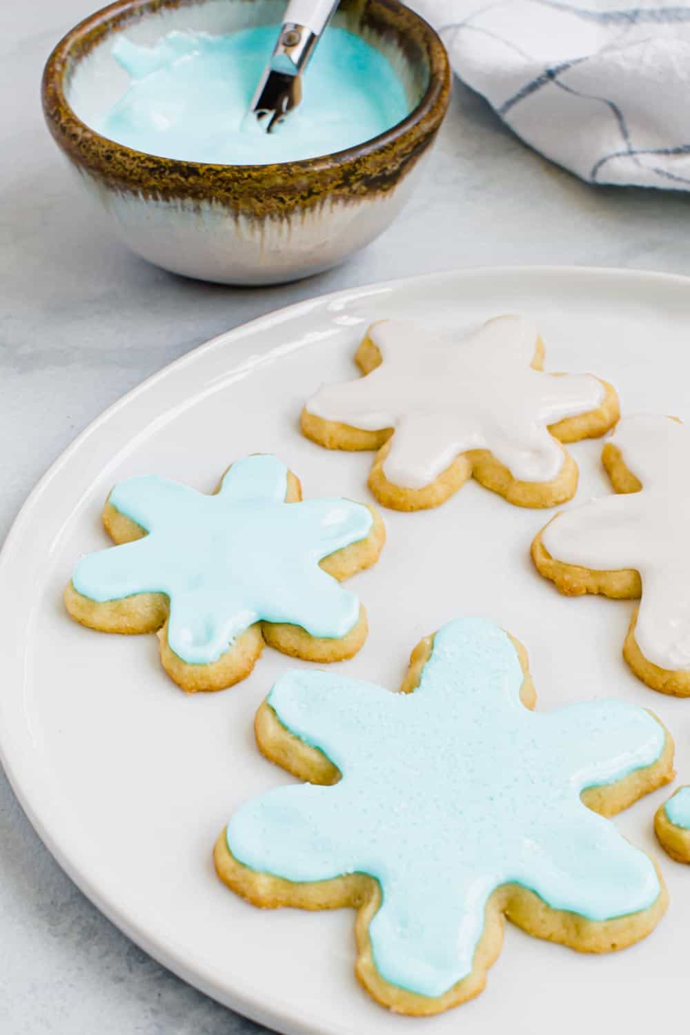 This classic and simple royal icing recipe is a cookie decorating staple with a smooth consistency that sets quickly without hardening too much. Made with meringue powder it has a delicious taste and a smooth texture that's perfect for flooding and piping cookies. Iced sugar cookies using royal icing.