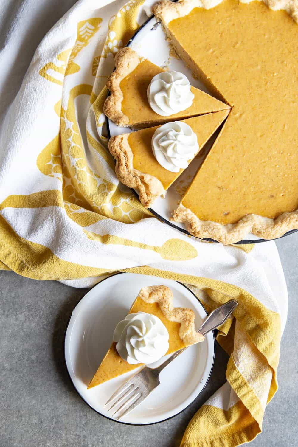 This Sweet Potato Pie is unlike any others you’ve eaten. The filling is made with cream cheese for a cheesecake like creaminess and texture you won’t be able to resist. A slice of sweet potato pie on a plate next to the pie in the pie dish