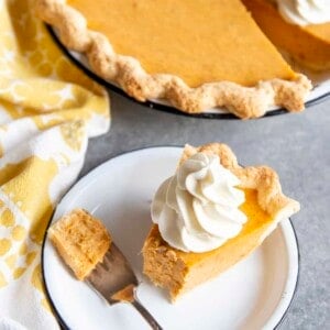 Partial eaten slice of sweet potato pie on a plate next to the pie dish