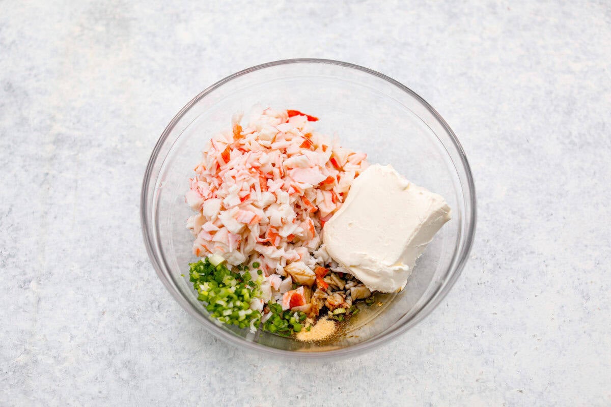 Crab Rangoons are a fun, Asian-inspired appetizer filled with crab meat, smooth cream cheese, and seasoning. Wrapped in a wonton wrapper and deep-fried, they are irresistible! Overhead shot of filling ingredients all in a mixing bowl.
