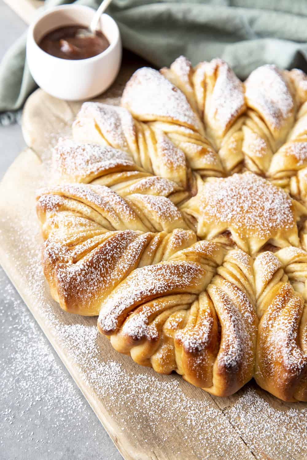 Star Bread is a visually stunning, decadent tasting sweet bread, that will be the talk of the table. Whether it's for the holidays or a special occasion this eye pleasing, mouth watering bread is the way to go. Star bread on serving bread and dusted with powdered sugar.