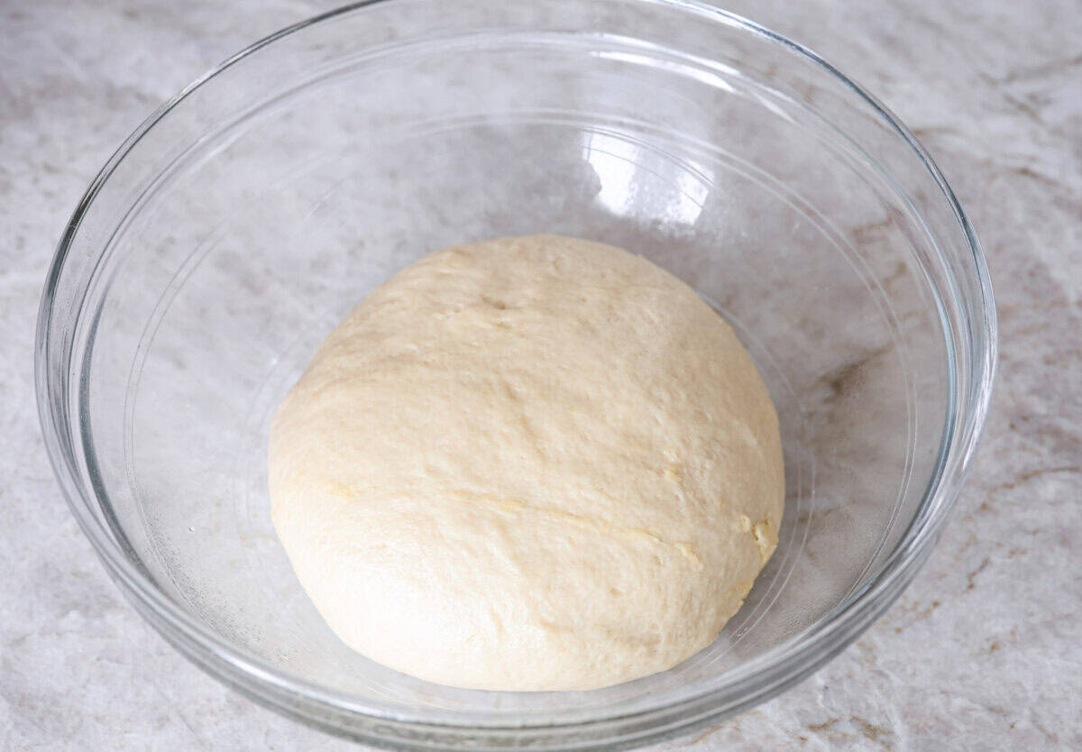 Lion House Rolls are the best dinner rolls for holiday meals or any occasion. These buttery, super-soft rolls are the perfect vehicle for soaking up delicious soups, sauces, and gravies. Overhead shot of lion house rolls dough in a greased bowl.