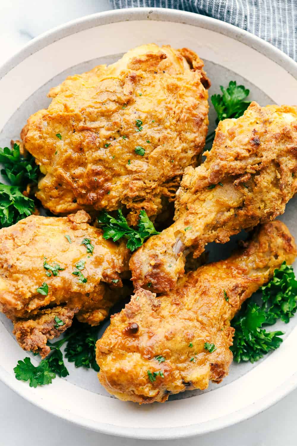 Crispy Air Fryer "Fried" Chicken is what Air Fryers were created to do! Crunchy golden seasoned outside, and tender, juicy, full of flavor inside! This is how chicken was meant to be eaten. Air Fryer Fried Chicken on a plate.
