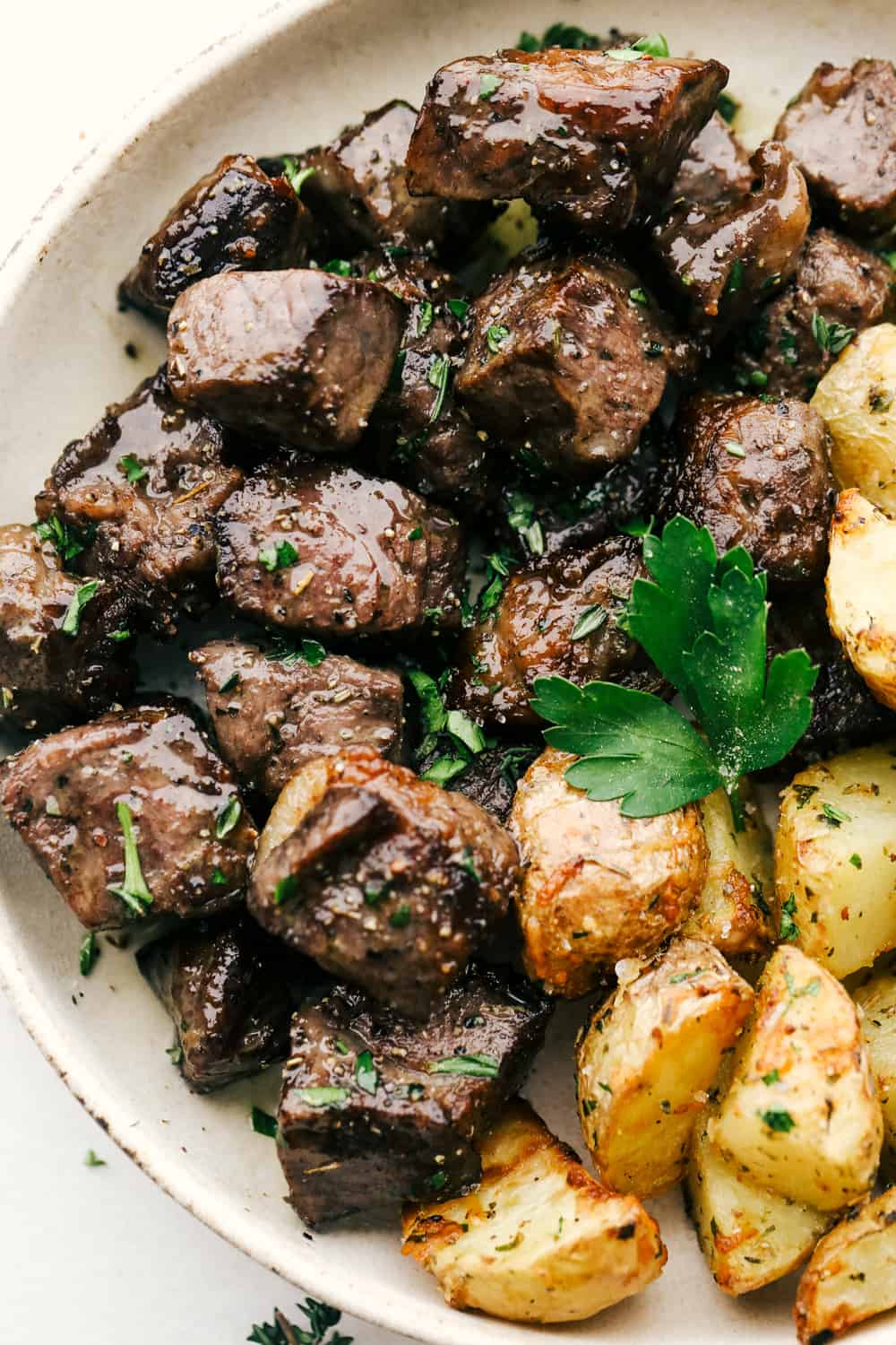 Air Fryer Garlic Steak Bites are tender morsels of steak perfection. Bite sized heaven in less than 15 minutes! Air Fryer steak bites with roasted potatoes on a plate.