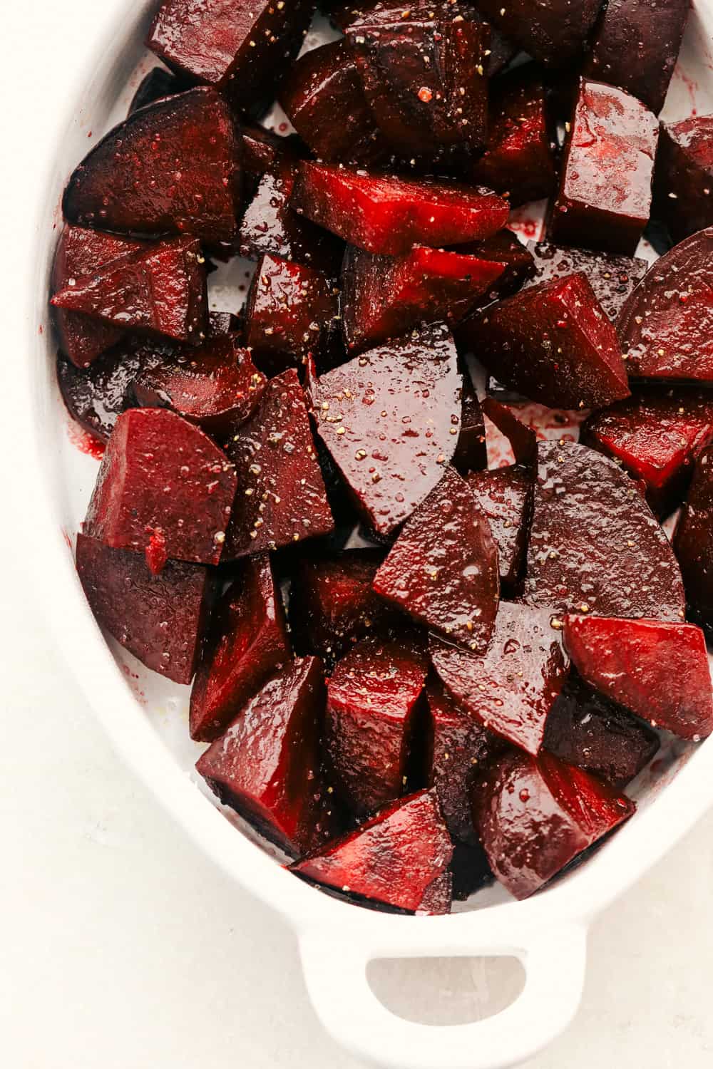 Perfect Roasted Beets are tender, flavorful and vibrant in color. These beets are the perfect companion to most any dish and are delish add ins to salads! Try these today! Seasoned beets in a roasting pan.