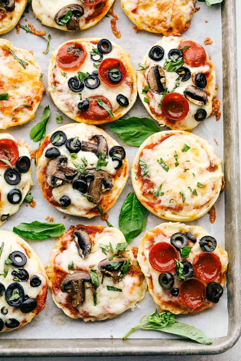 Easiest English Muffin Pizzas are a quick perfect dinner or lunch that everyone can customize. Whether you like just cheese or pepperoni and mushrooms, personalized english muffin pizzas are perfect for the whole family. Toasty and perfect english muffin pizzas on a cookie sheet.