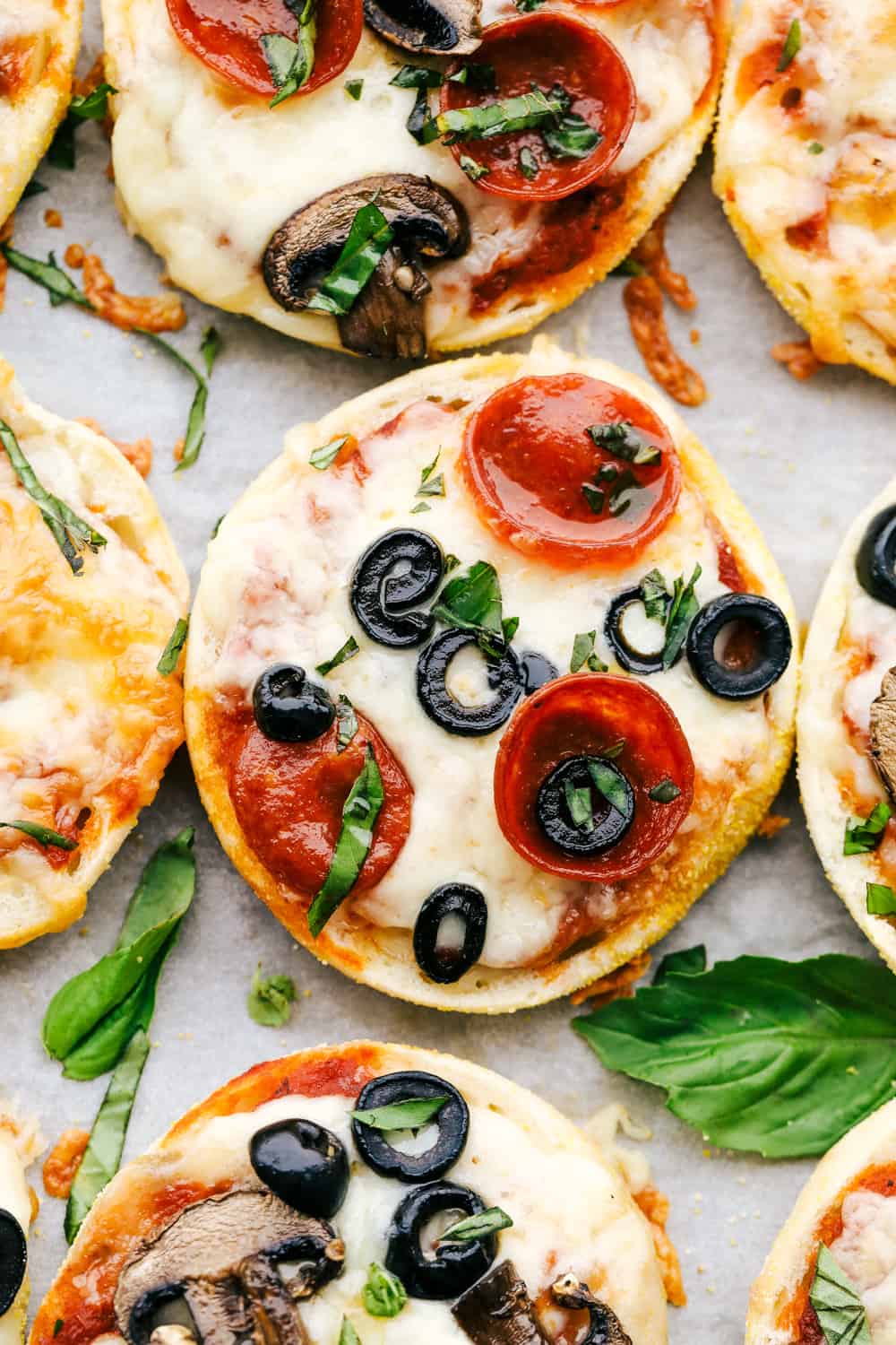 Easiest English Muffin Pizzas are a quick perfect dinner or lunch that everyone can customize. Whether you like just cheese or pepperoni and mushrooms, personalized english muffin pizzas are perfect for the whole family. English muffin pizza topped with olives and pepperoni.