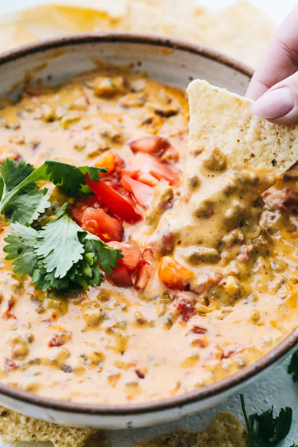 Amazing Rotel Dip is the easiest and most delectable dip for any occasion! Perfectly spiced hamburger, creamy cheese and full flavored Rotel tomatoes combine in this quick appetizer, everyone will love. Using a corn chip to dip into the Rotel Dip.