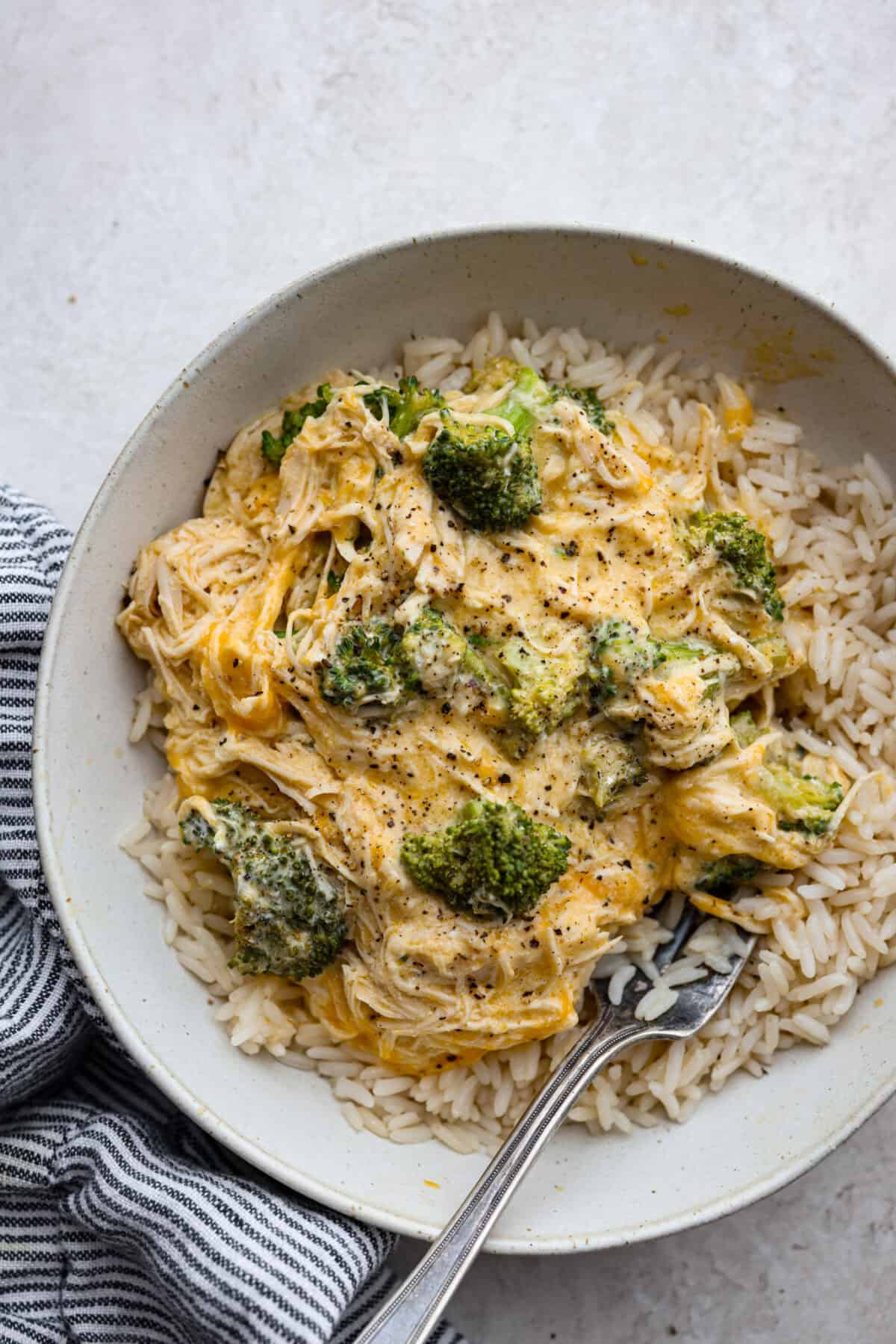 Slow-cooker creamy chicken and broccoli over rice is a super easy, delicious meal the whole family will love! Moist chicken and tender broccoli combine in a cheesy sauce that's absolutely divine.ย Overhead shot of slow cooker creamy chicken and broccoli over rice plated.