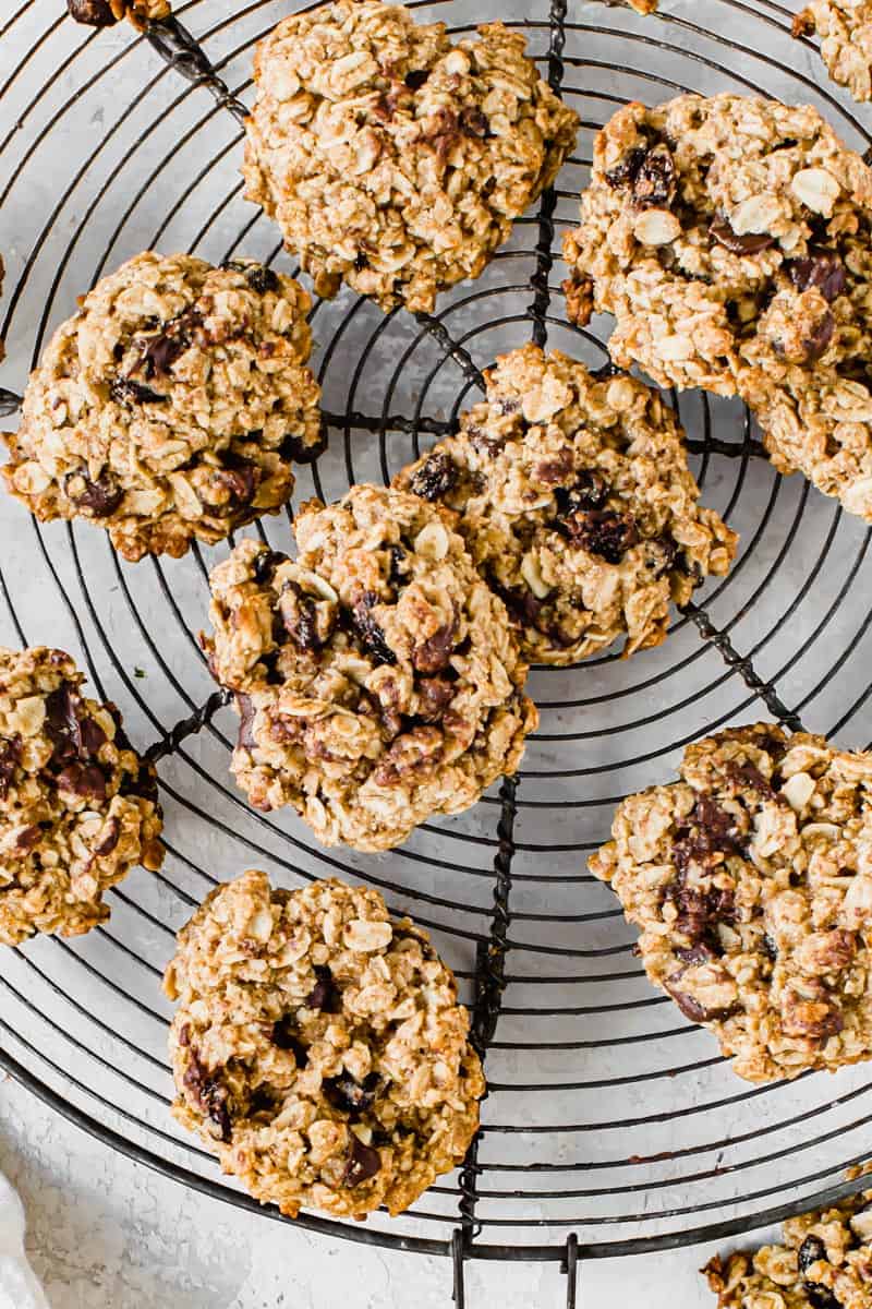 Sweet and slightly chewy, these Healthy Oatmeal Cookies taste just as good as the classic. With better ingredients such as coconut oil and maple syrup instead of sugar, these cookies have a healthier nutrition label than others.ย Oatmeal cookies on a round wire rack.