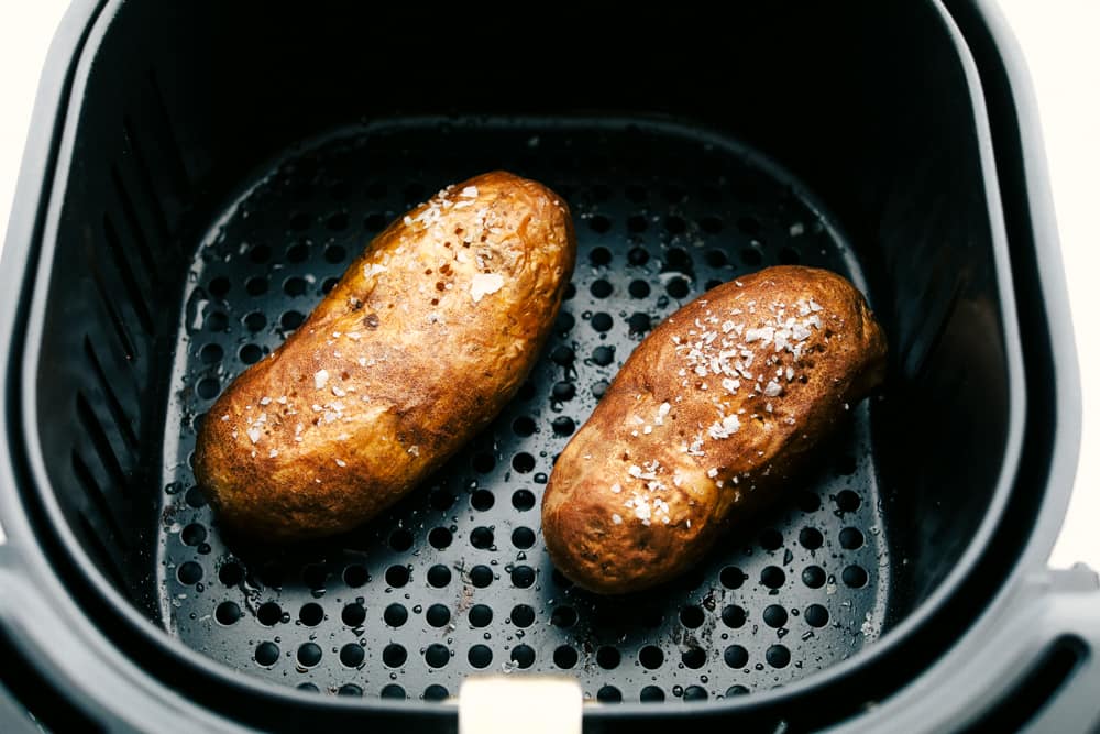 Perfect Air Fryer Baked Potatoes are crispy on the outside and tender fluffy on the inside. Perfect addition to any meal, or a meal all on it's own! Cooked baked potatoes, golden brown and crispy.