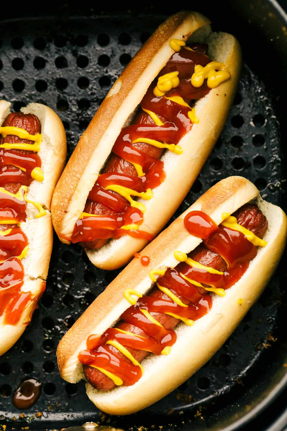 Air Fryer Hot Dogs taste better than any grilled, boiled or game-day hot dog you have ever had! Making them in the Air Fryer is a game changer! Hot dogs in buns with ketchup and mustard up close.
