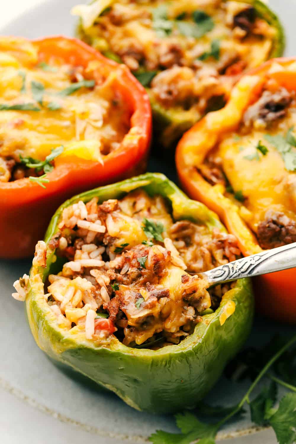 A super easy and delicious dinner begins here with Air Fryer Stuffed Peppers. Filled with a savory mixture and cooked to tender perfection, it is going to be a family favorite! Scooping out the savory filling for stuffed peppers.
