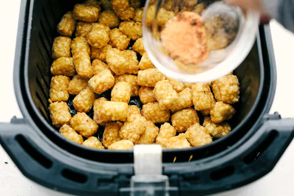 Air Fryer Tater Tots are just about the greatest thing to happen to potatoes ever! Crispy golden on the outside and tender on the inside, these are insanely delicious! Seasoning frozen tater tots in the air fryer.