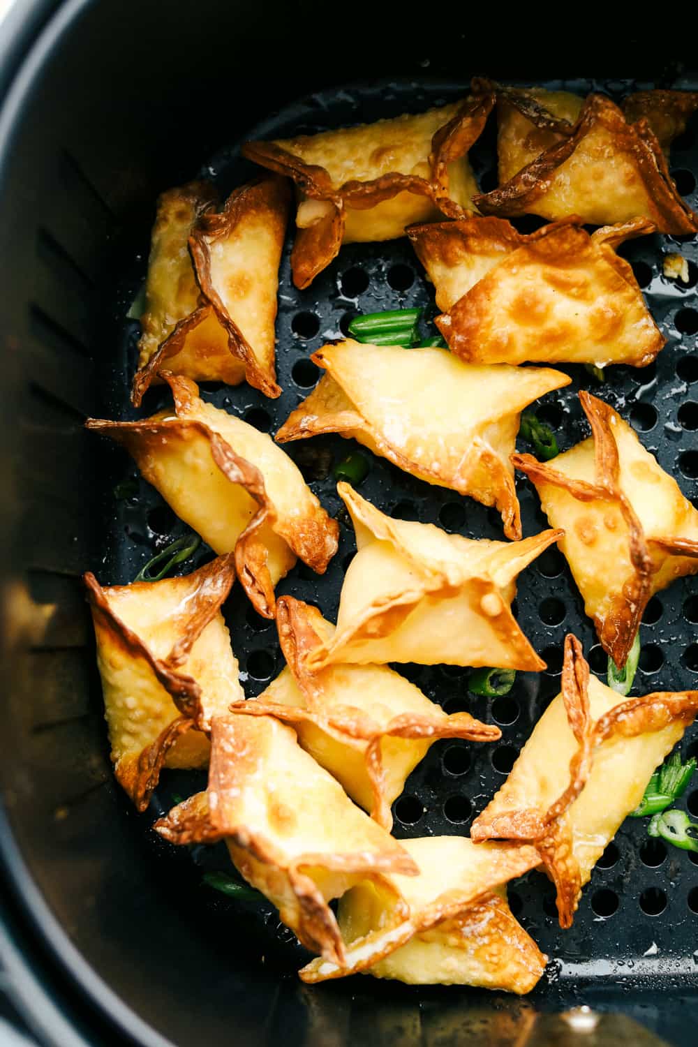 Air Fryer Cream Cheese Wontons are creamy and smooth inside and crispy golden outside. These wontons are the perfect appetizer or snack! Crispy air fryer wontons in air fryer basket.