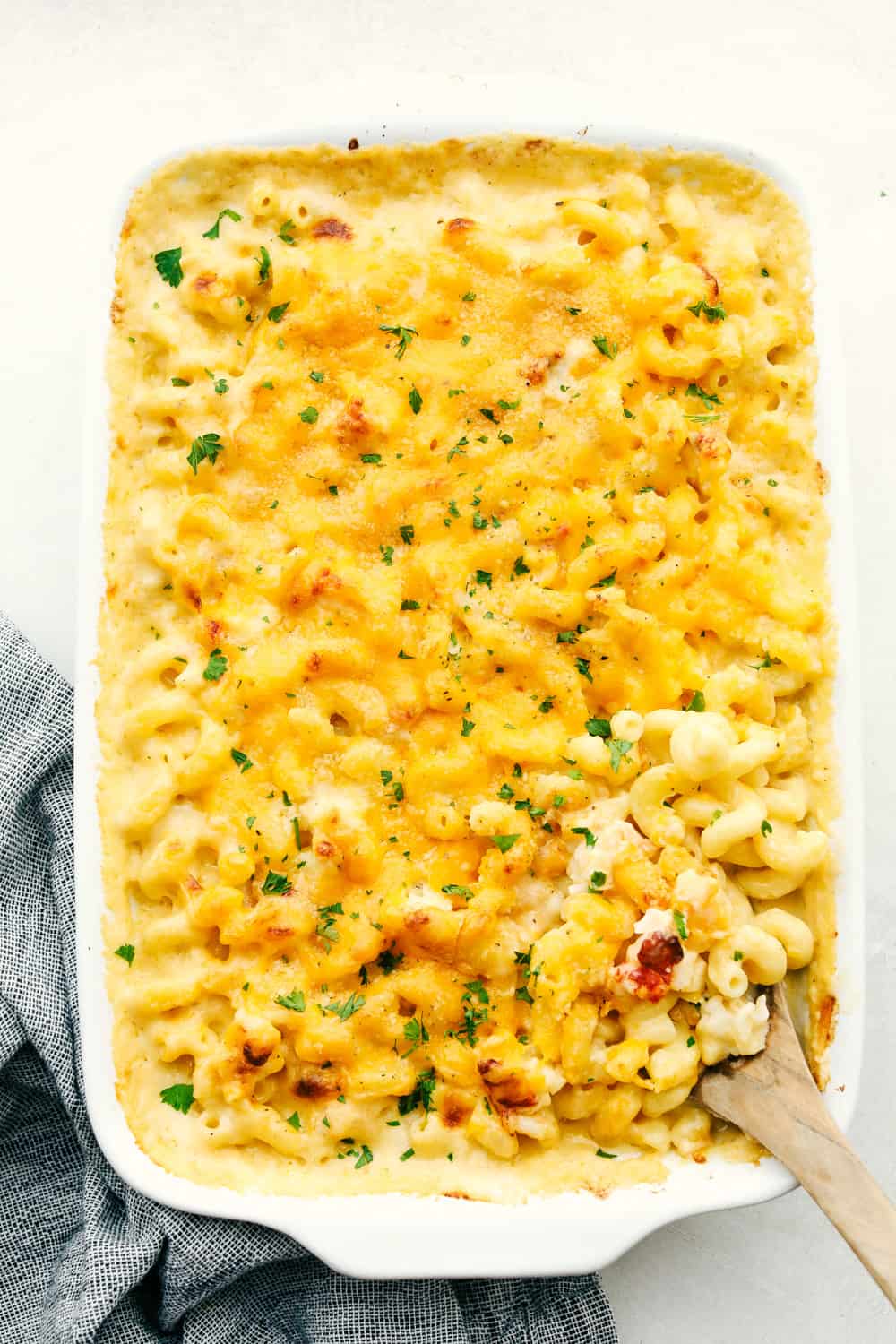 It's ooey and gooey, full of cheese and decadent rich lobster, this truly is an Incredible Lobster Mac and Cheese. Perfect for a special night or occasion, it's a macaroni and cheese that's sure to impress. Baked lobster macaroni and cheese in a white dish.