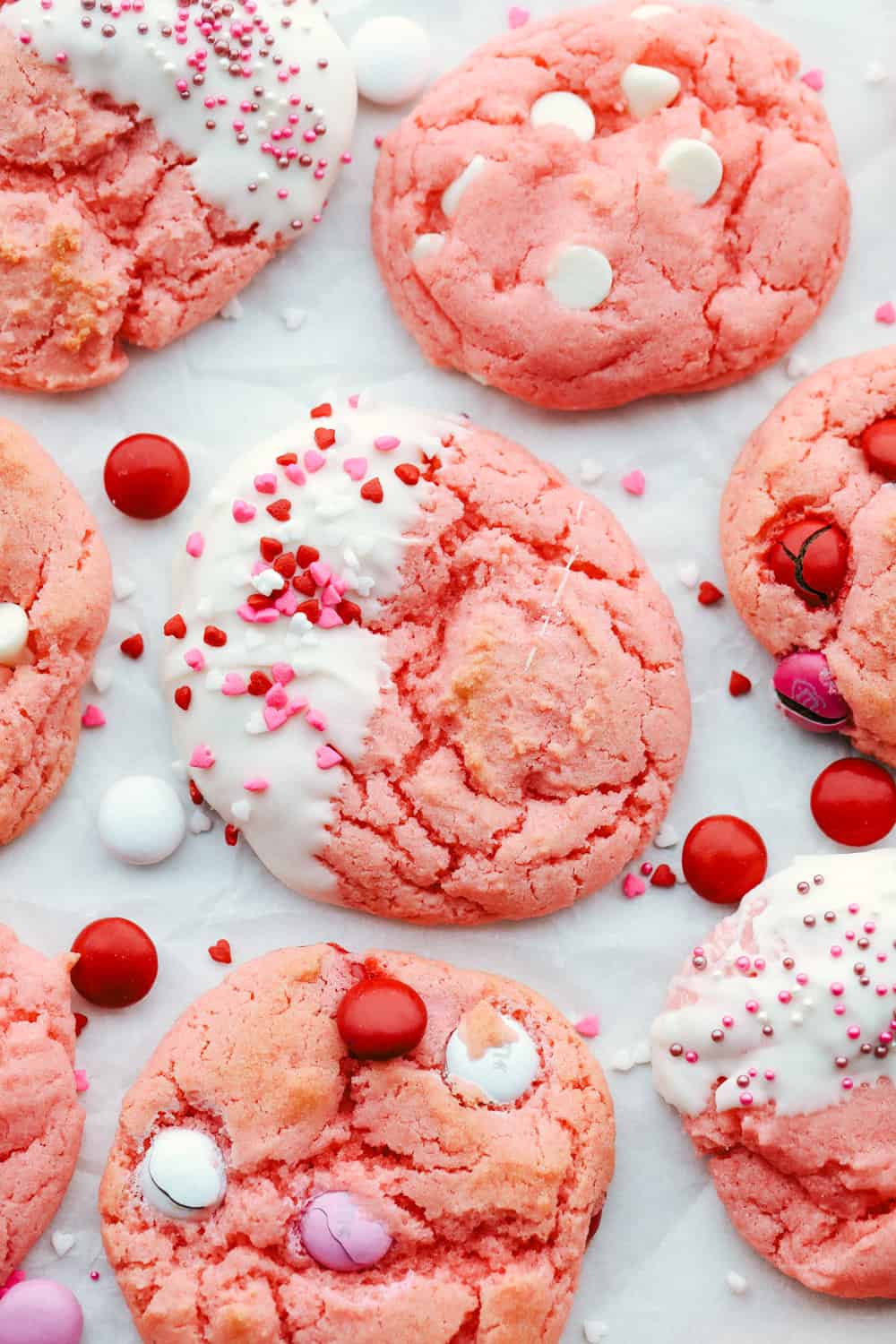 Strawberry cake mix cookies are a sweet treat that is super fast and easy! Make these pink cookies for Valentine's Day, baby showers, or any special occasion. Strawberry cookies with M&M's, white chocolate chips and sprinkles.