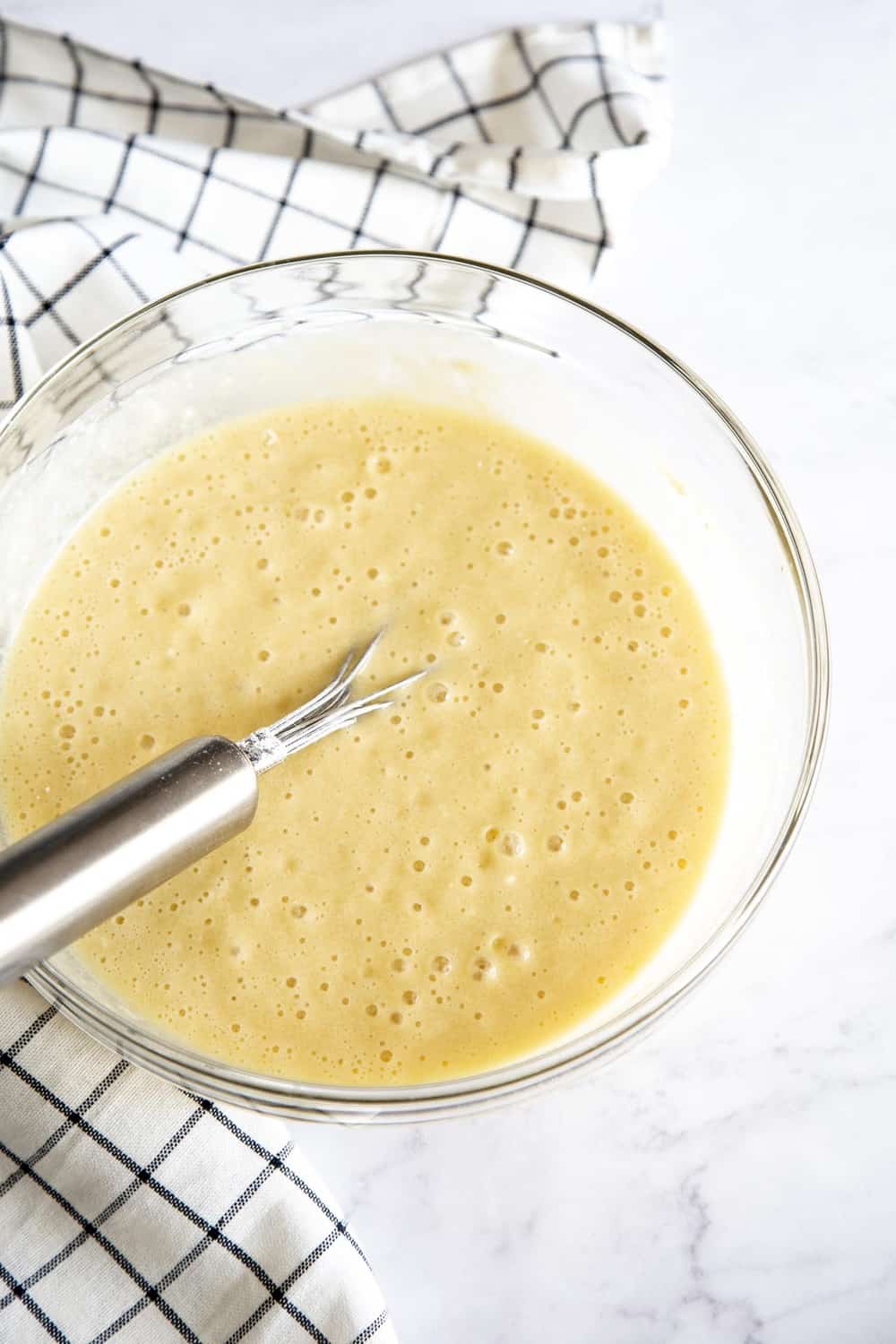 Boston Cream Cake is an American classic sure to win you over. It's a decadent light, fluffy cake, filled with a vanilla custard and topped with a rich chocolate ganache. Whisking up the boston cream cake batter.