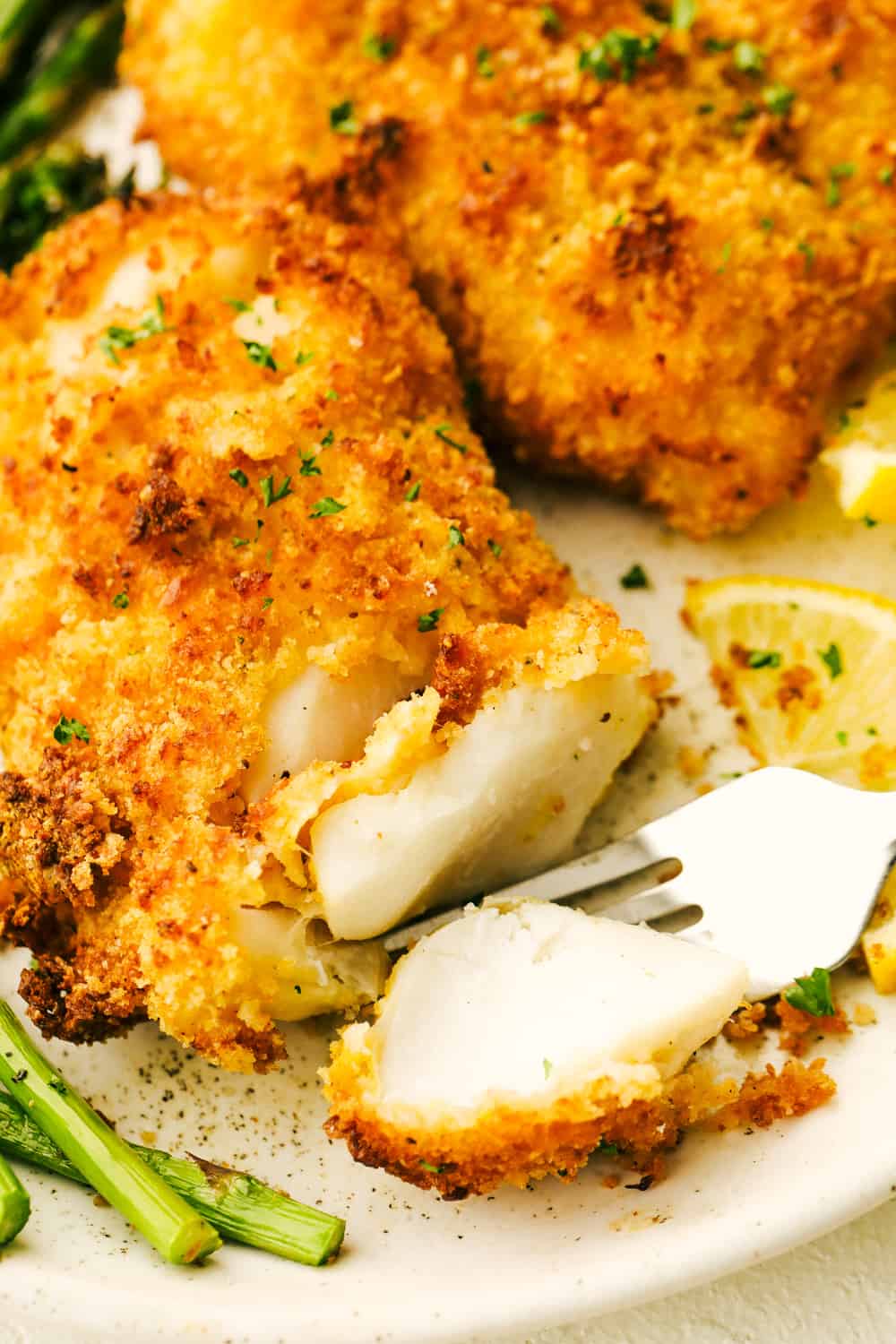 Air Fryer Cod will change the way you eat fish! Crispy golden outside and flakey tender inside, you are going to love this! Upclose picture of a fork cutting into the air fryer cod.