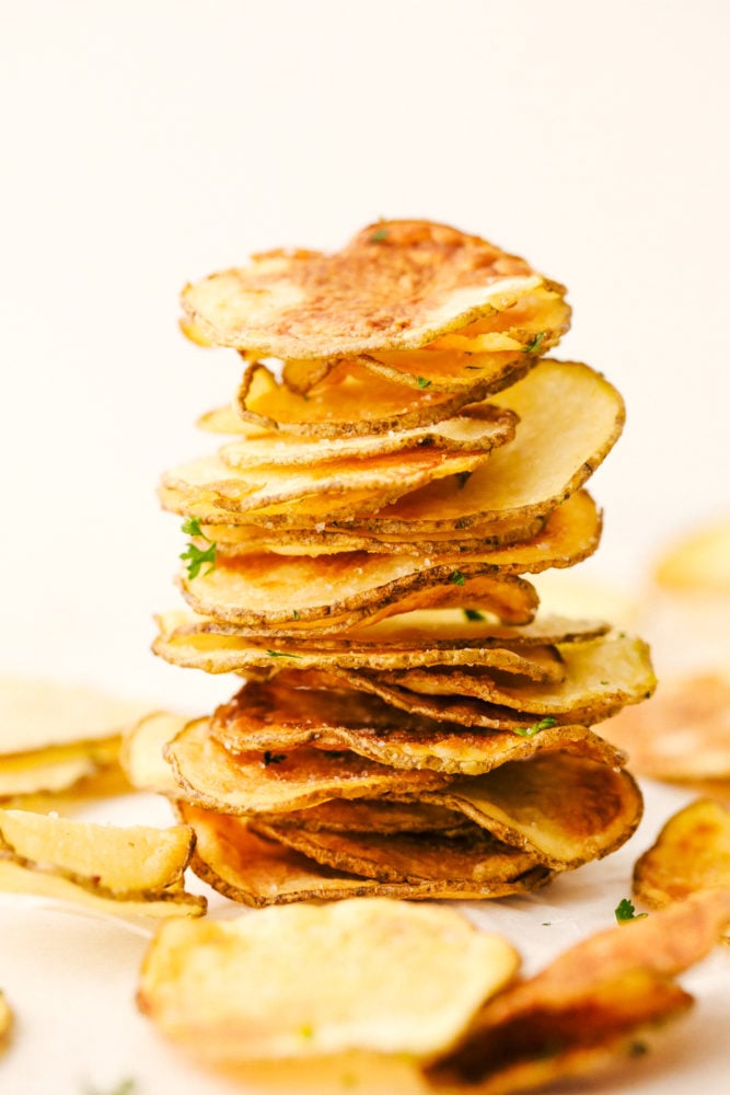 Air Fryer Potato Chips are a chip lovers dream come true! Now you can have all the chips, and none of the guilt! Air fryer potato chips stacked and ready to eat.