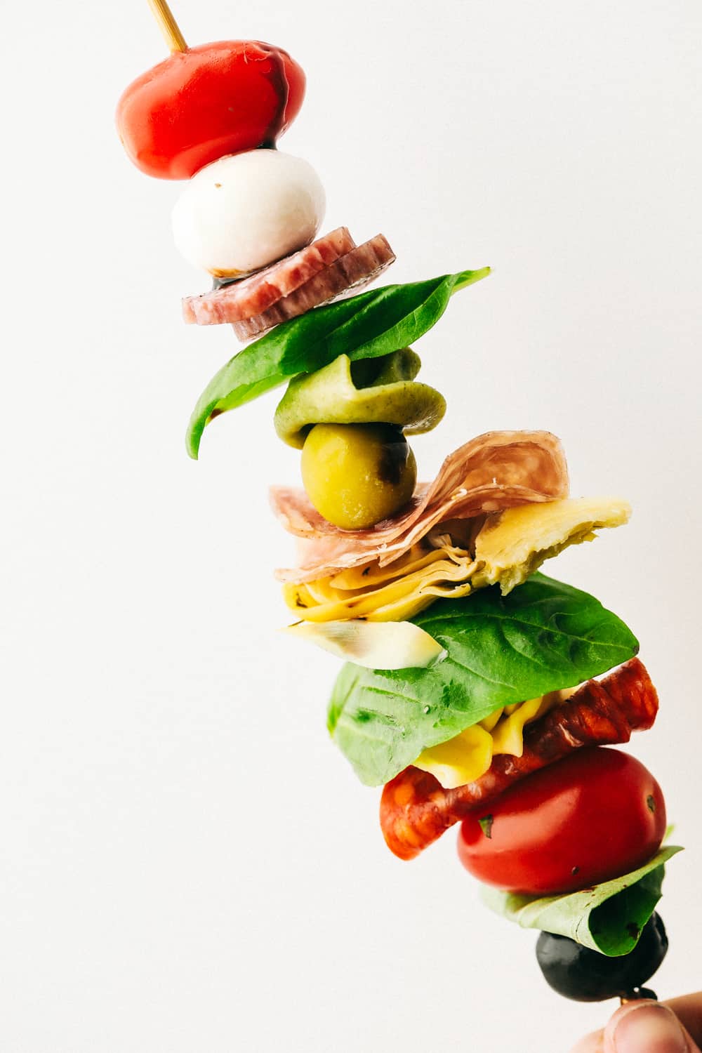 Antipasto Skewers are a super easy and delicious appetizer, perfect for any occasion. Colorful and full of flavor, these are true crowd pleaser! Up close look at an antipasto skewer layered with ingredients.
