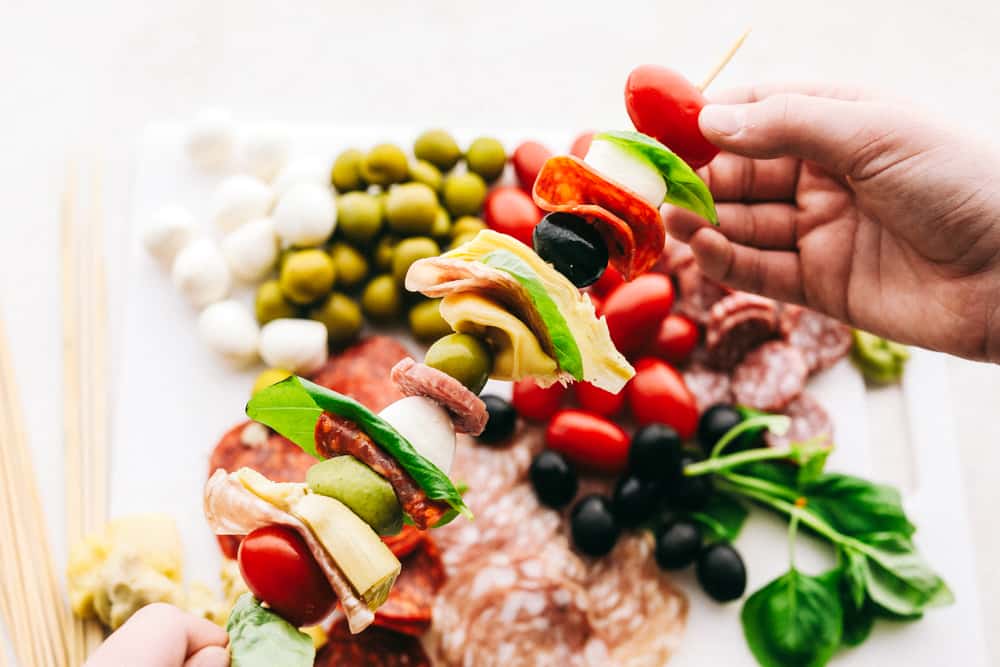 Antipasto Skewers are a super easy and delicious appetizer, perfect for any occasion. Colorful and full of flavor, these are true crowd pleaser! Layering ingredients on skewers for antipasto skewers.