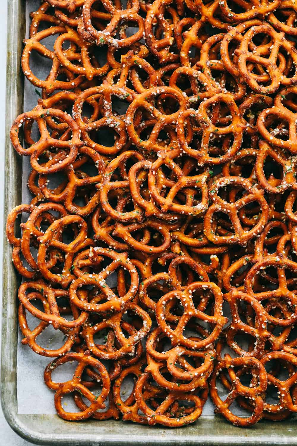 For a quick snack make these Ranch Pretzels. These make the best party, movie night, or after school snack! Ranch covered pretzels on a cookie sheet.