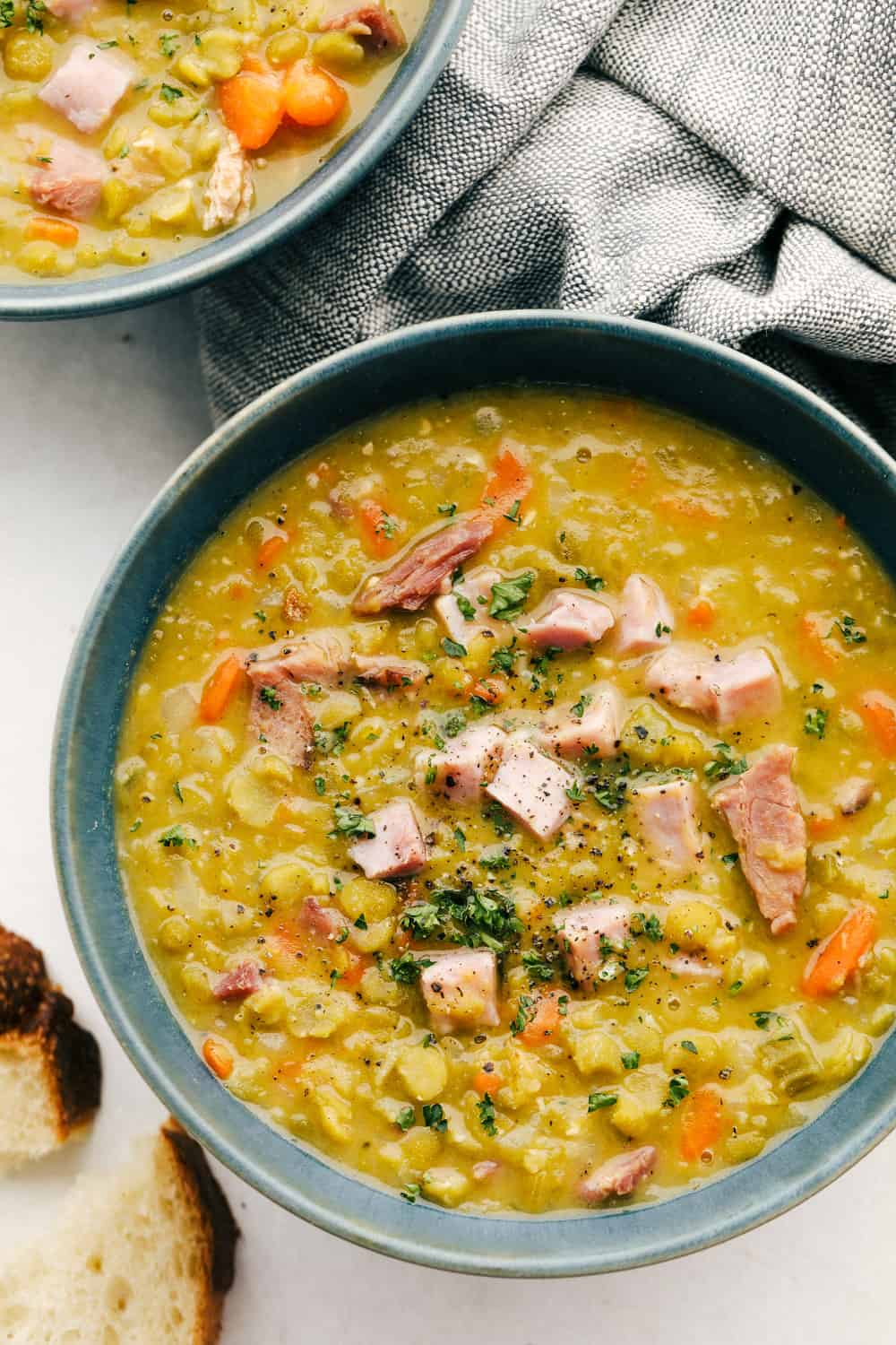 Split Pea Soup with ham is the perfect comfort food for any occasion. Full of vegetables, flavored with ham and cooked to perfection, you and your family are going to LOVE this soup. Homemade Split pea soup with ham in a bowl.