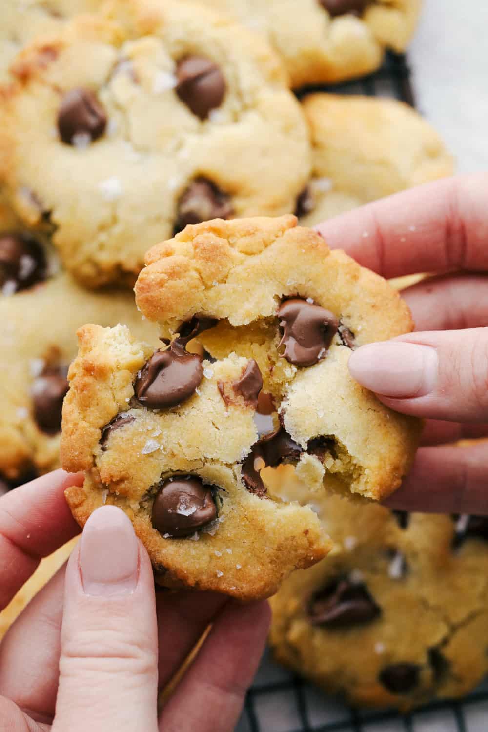 Air Fryer Chocolate Chip Cookies are crispy on the outside, ooey gooey on the inside. These cookies are going to change the way you cookie! Breaking apart a cookie with melting chocolate.