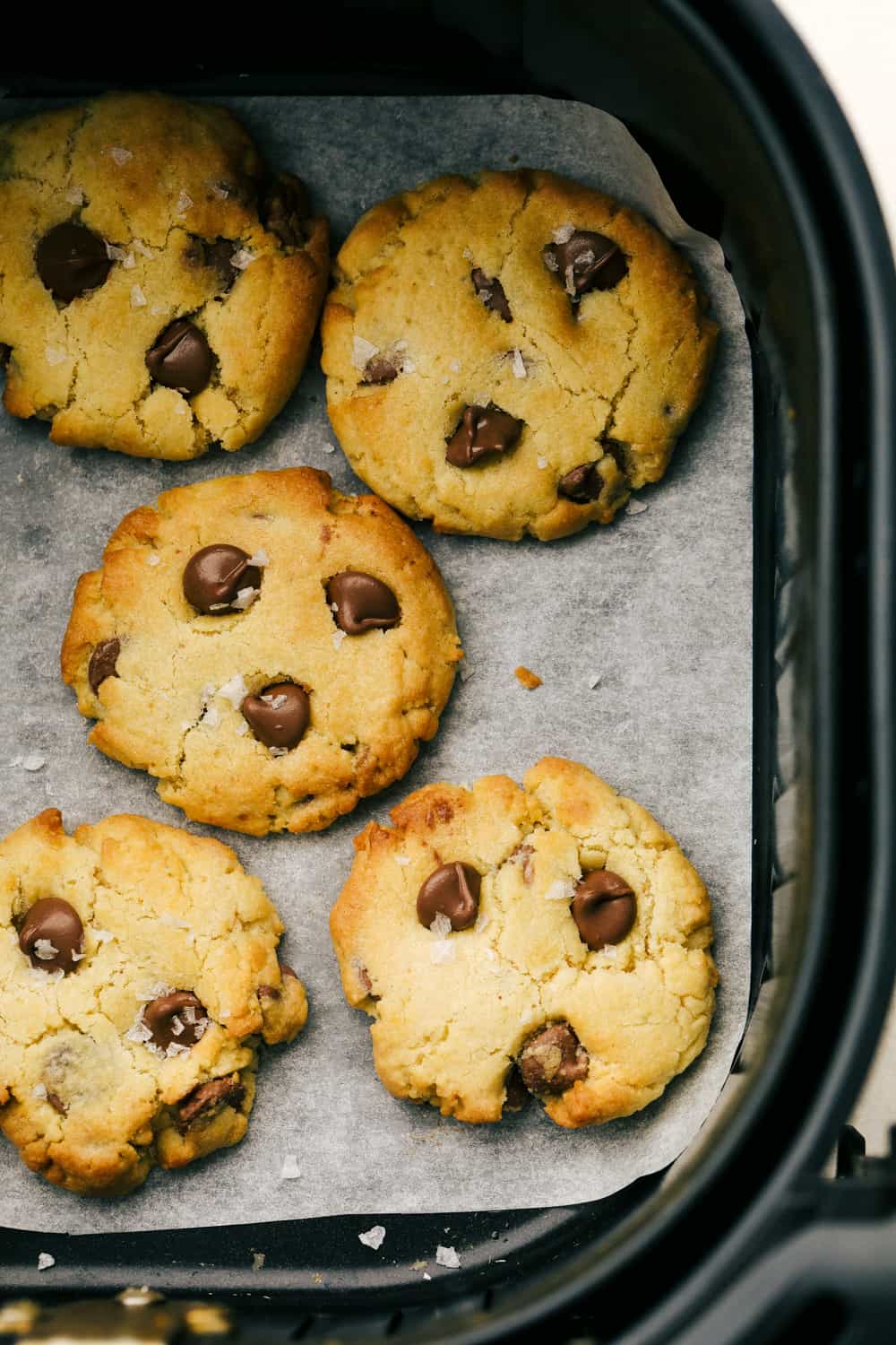 Air Fryer Chocolate Chip Cookies are crispy on the outside, ooey gooey on the inside. These cookies are going to change the way you cookie! Golden brown cookies in the air fryer basket.