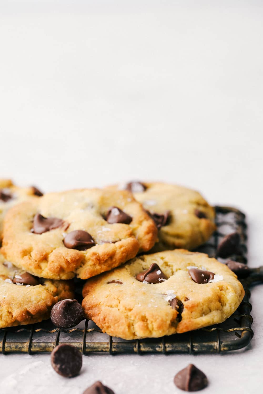 Air Fryer Chocolate Chip Cookies are crispy on the outside, ooey gooey on the inside. These cookies are going to change the way you cookie! Air fryer chocolate chips stacked on a cooling rack.