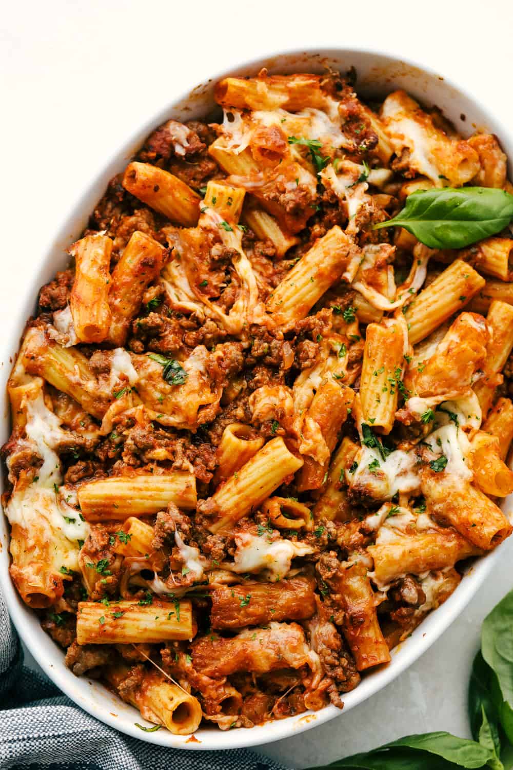 Baked Rigatoni is full of zesty meat, tender noodles and lots of cheese!ย Super simple this is the ultimate comfort food! Baked rigatoni in a white bowl.
