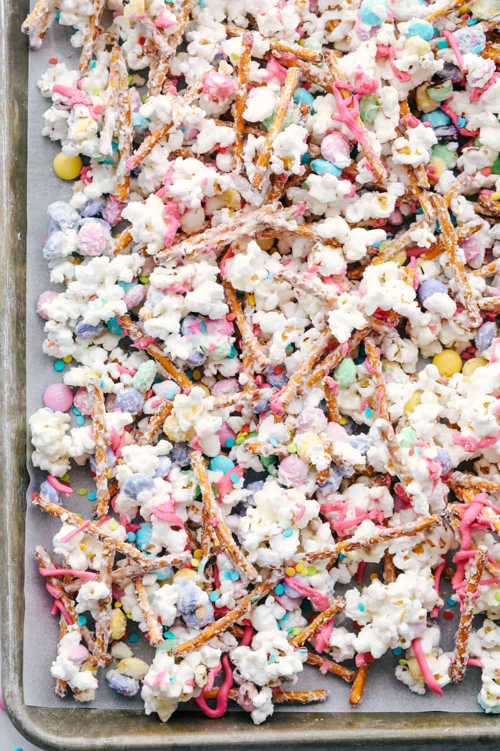 Funfetti Popcorn or Bunny Bait is a fun springtime treat that is sure to satisfy! This is a sweet salty colorful treat perfect for Easter or any other special occasion! A sheet pan with colorful bunny bait cooling.