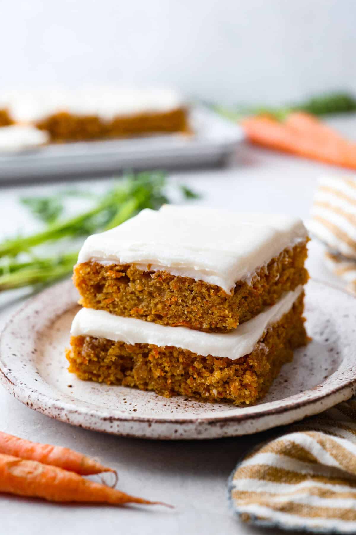 Stacked carrot cake bars with cream cheese frosting. 