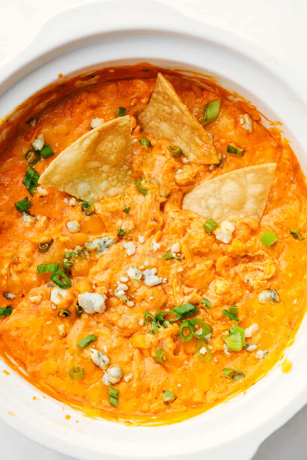 Crockpot Buffalo Chicken Dip is an insanely delicious way to jazz up your next party. Chock full of intense but balanced flavors this appetizer is going to disappear fast. Chips placed in buffalo chicken dip.